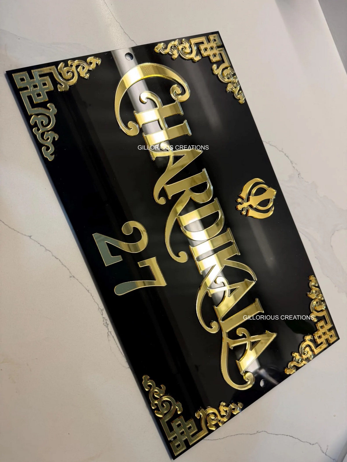 Mirror gold Chardi Kala letters and ornate 3D Khanda and corners on black acrylic sign close-up